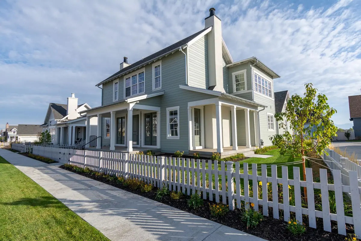 Two-story home with a white picket fence along a landscaped front yard